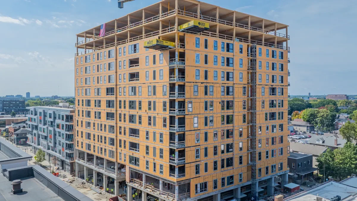 The exterior of the tall building under construction with exposed framing and windows.